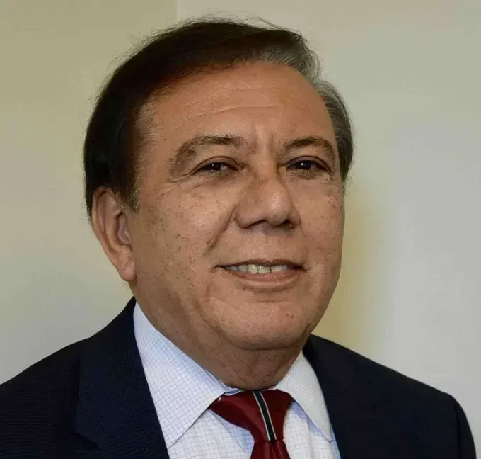A man in a suit and tie is smiling for the camera.