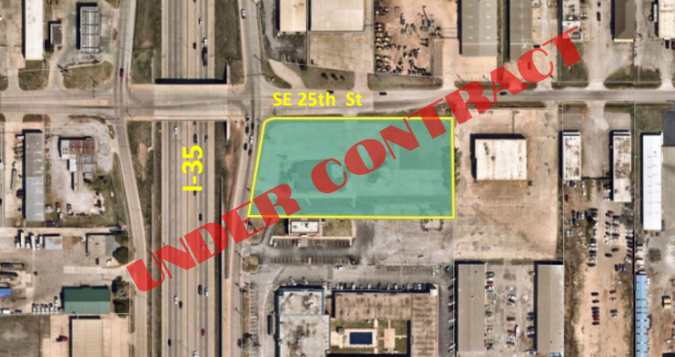 An aerial view of a city with a green area in the middle.