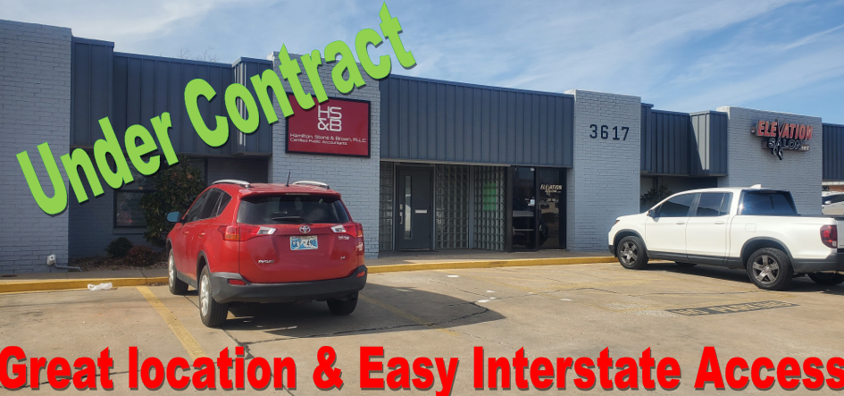 Commercial building exterior with a red SUV and white truck parked in front; text notes it is 