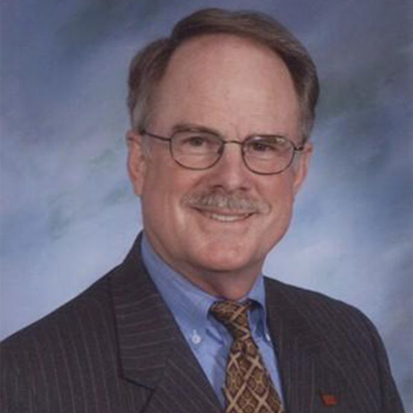 A man in a suit and tie is smiling for the camera