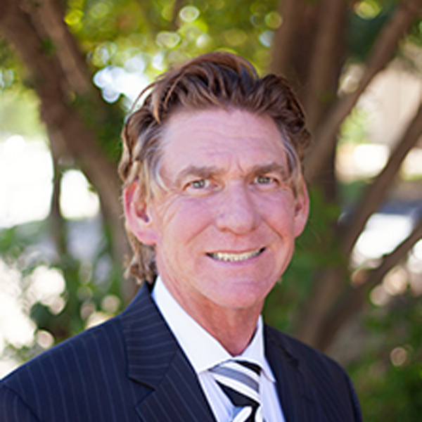 A man in a suit and tie is smiling for the camera.