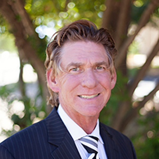A man in a suit and tie is smiling for the camera.
