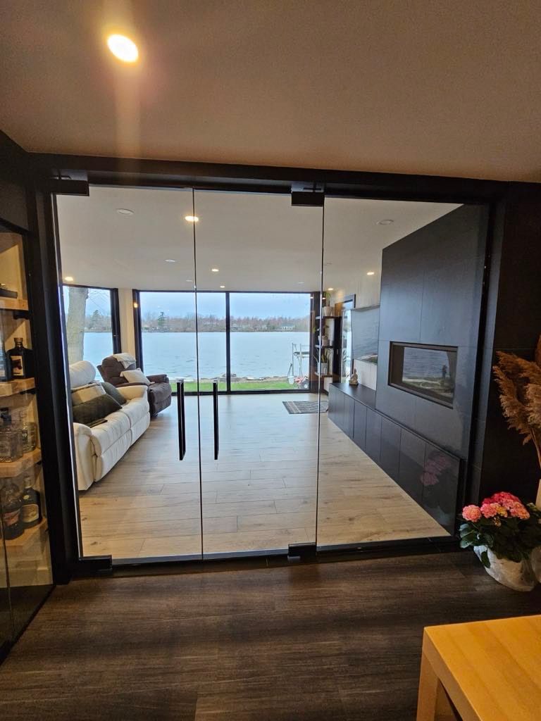 Un salon avec vue sur un lac à travers une porte vitrée.