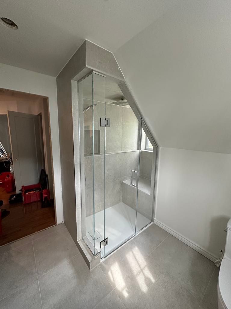 Une salle de bain avec une cabine de douche et un WC.