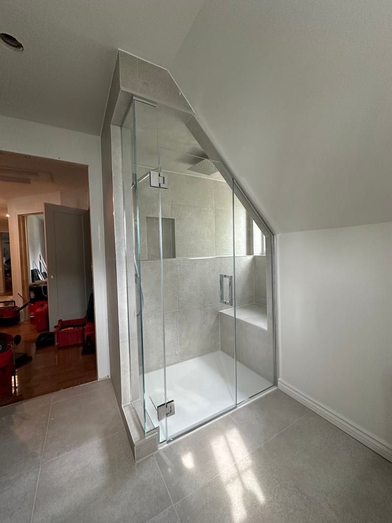 Une salle de bain avec douche à l'italienne et porte coulissante en verre.