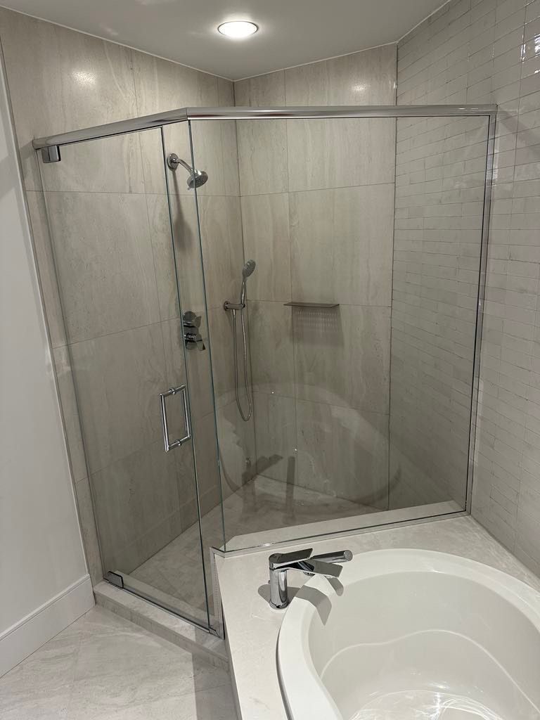 Une salle de bain avec une baignoire et une douche avec une porte vitrée.