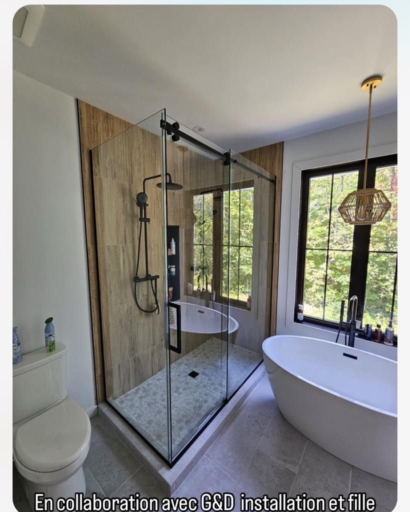 Une salle de bain avec baignoire, douche, WC et fenêtre.