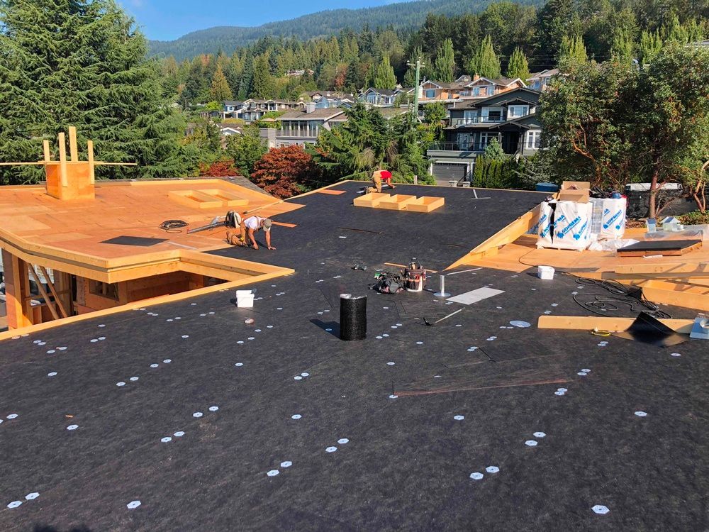 A group of people are working on a roof of a house.