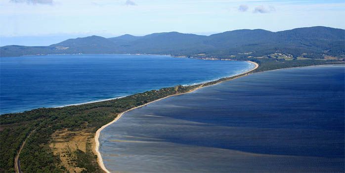 An aerial view of a large body of water with mountains in the background.