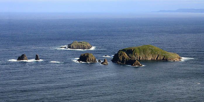A group of small islands in the middle of the ocean.