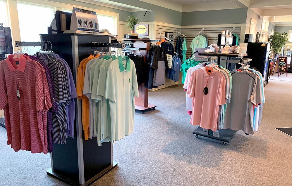 Golf apparel store, displaying various colored polo shirts on racks. The setting is bright with a neutral-toned floor.