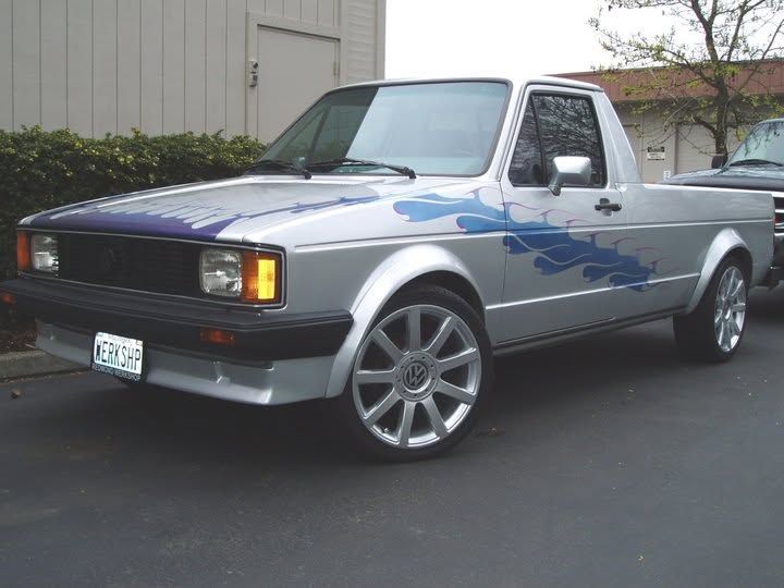 Silver pickup truck with blue flames, parked outdoors on a street