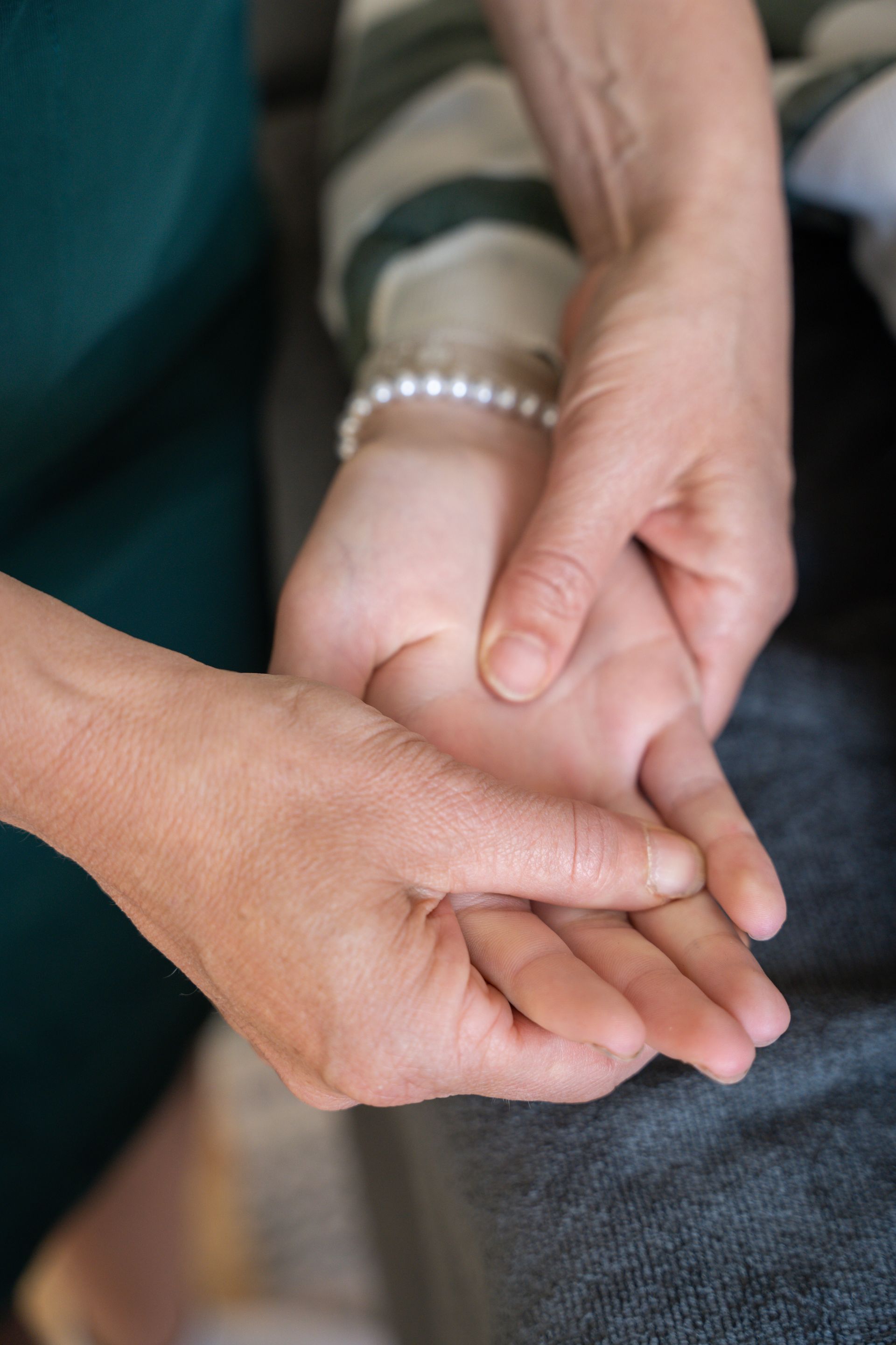 A person is holding another person 's hand with their fingers.