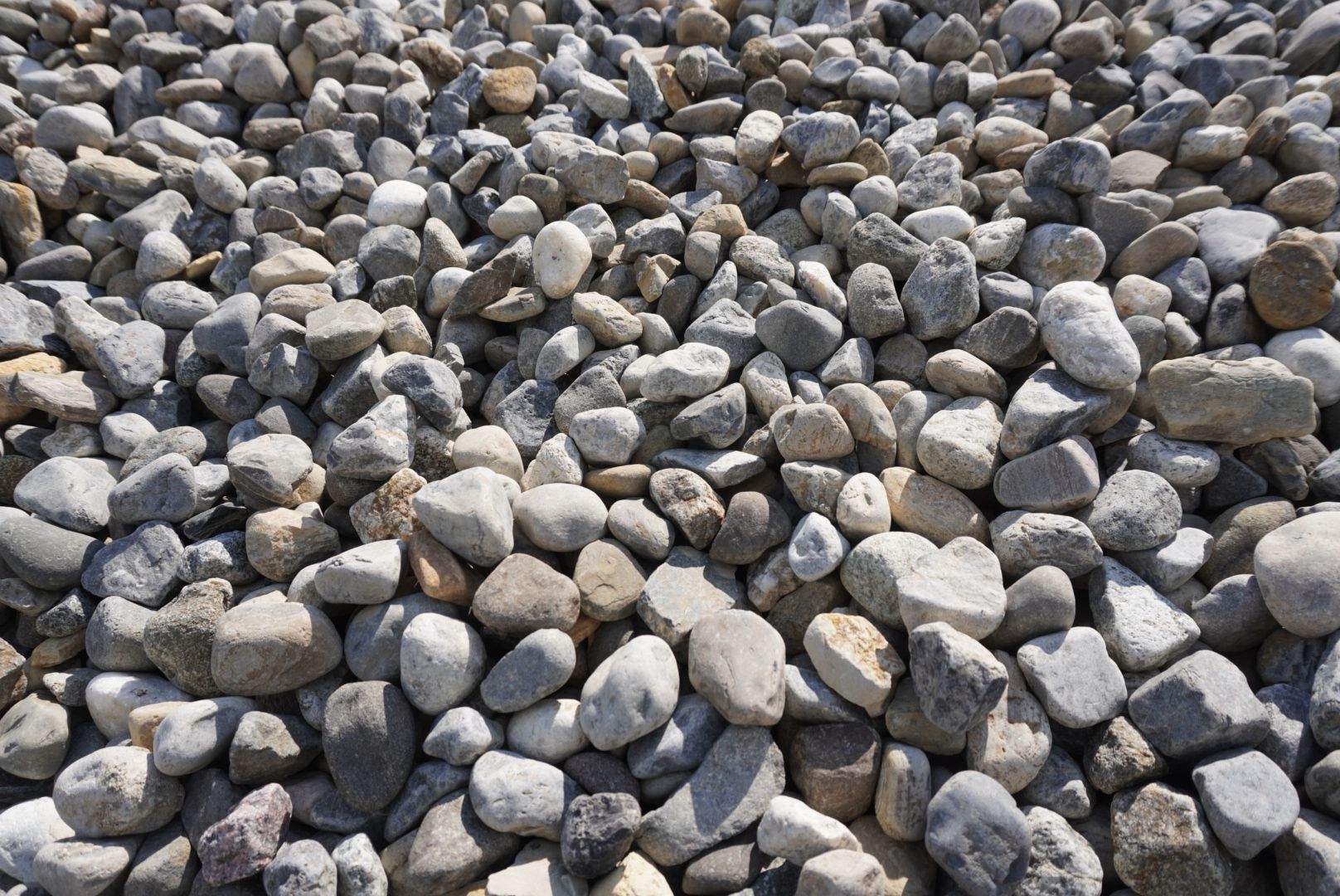 Close-up of a pile of small gray and beige stones or pebbles