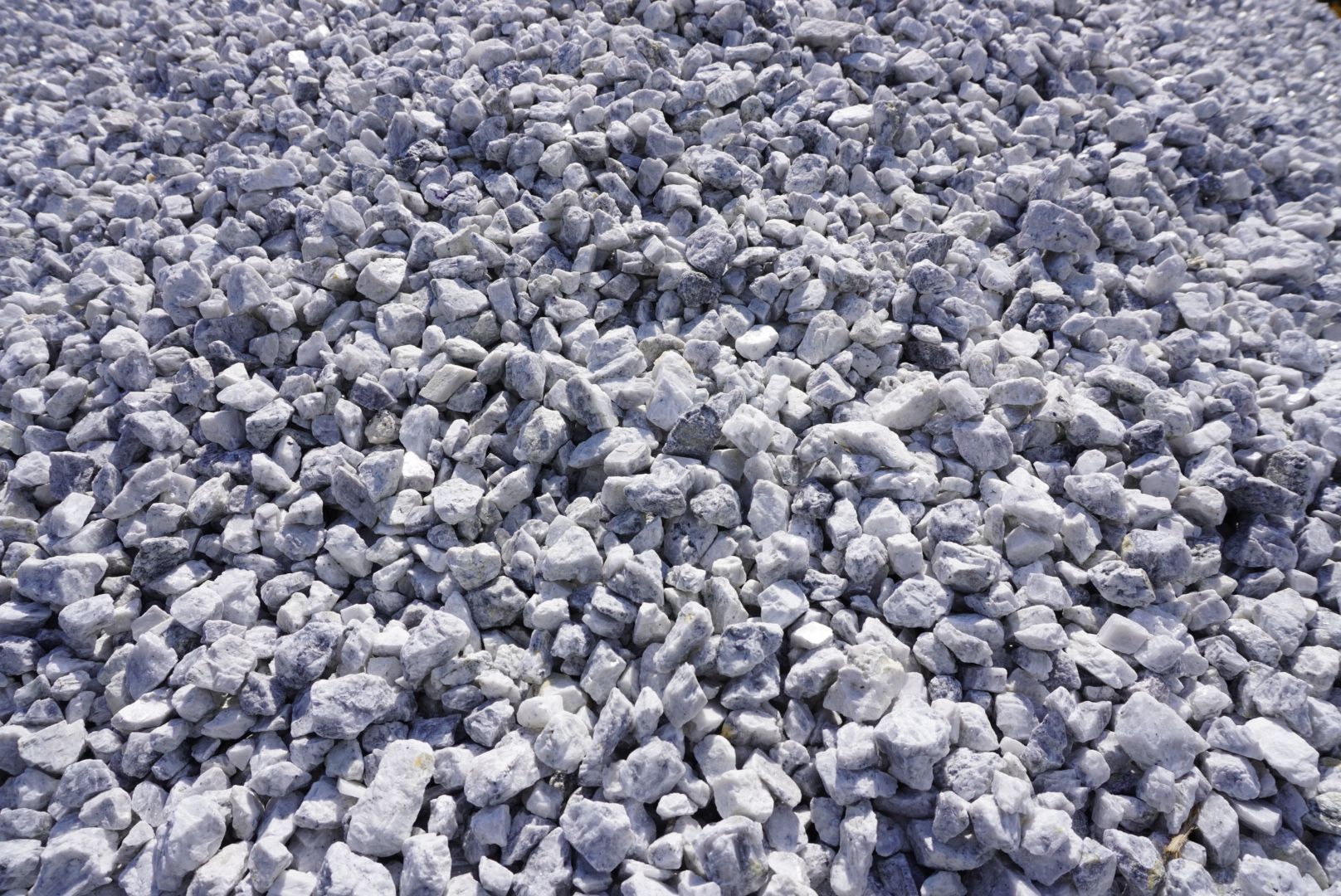 Gray crushed rocks covering the ground in a rough, rocky surface