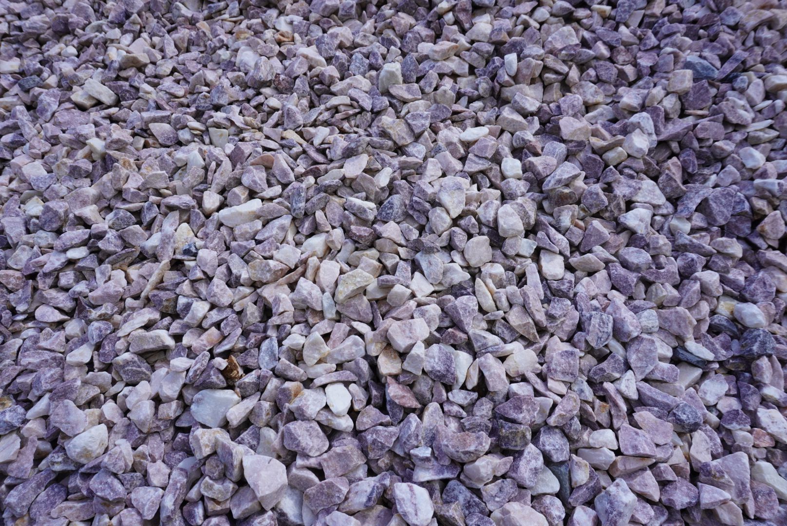 A pile of small gray and purple rocks covering the ground