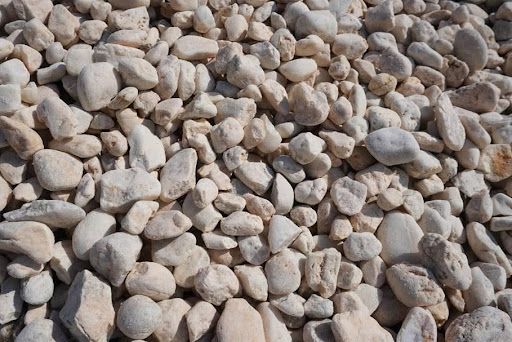 Pile of small light-colored rocks and pebbles covering the ground
