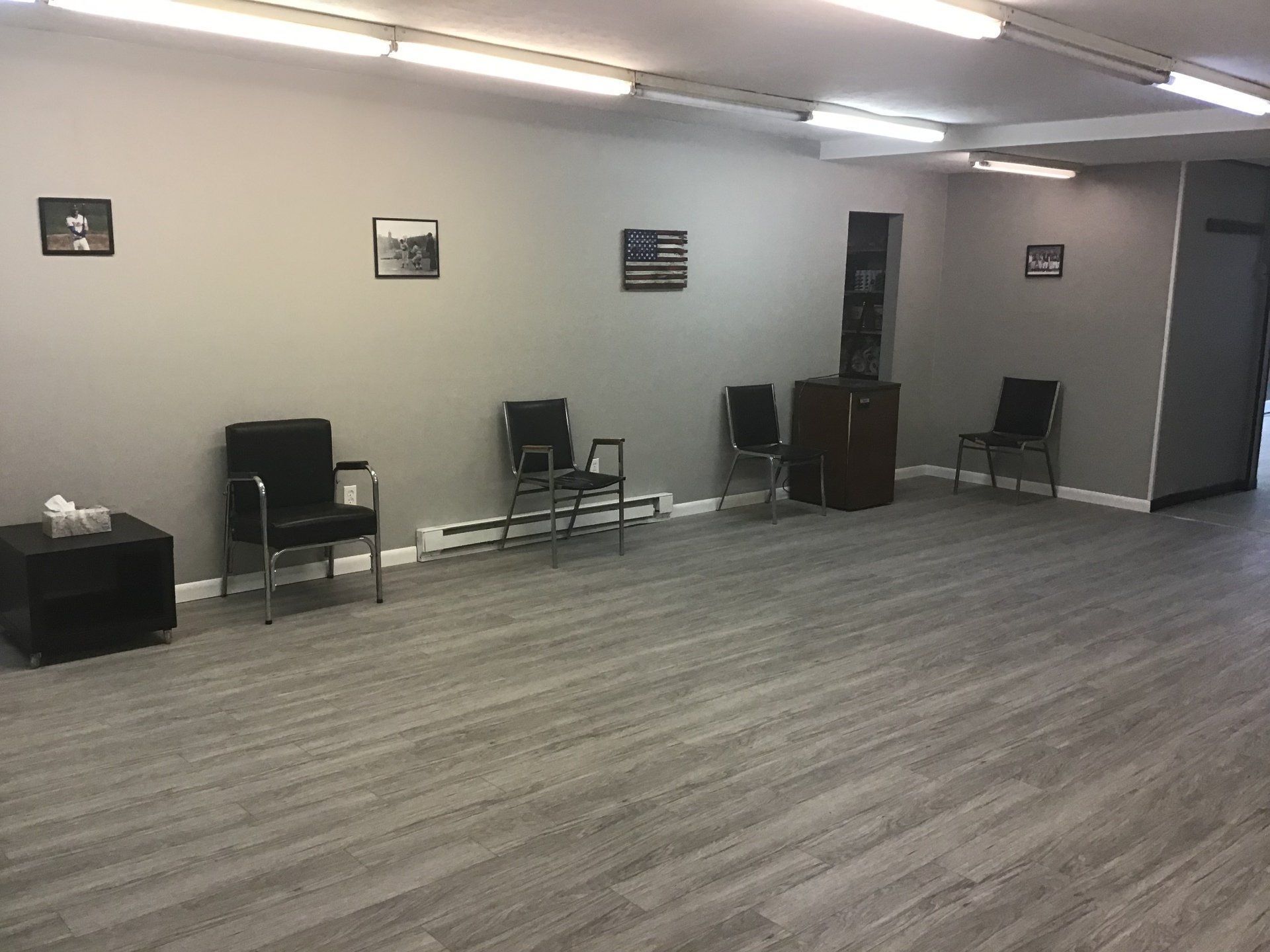 A waiting room with chairs and a table in it.