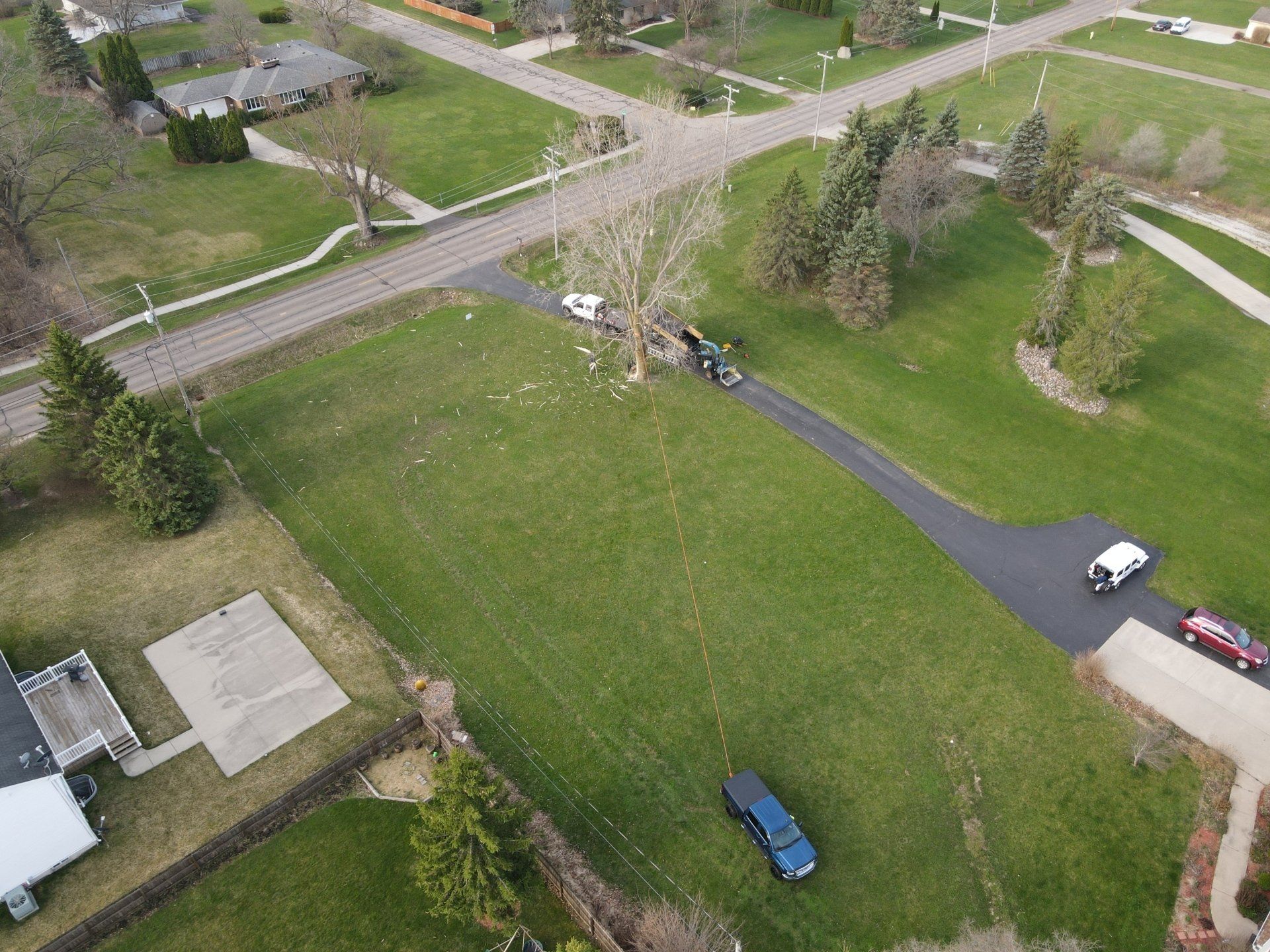 An aerial view of a residential area with cars parked on the side of the road.