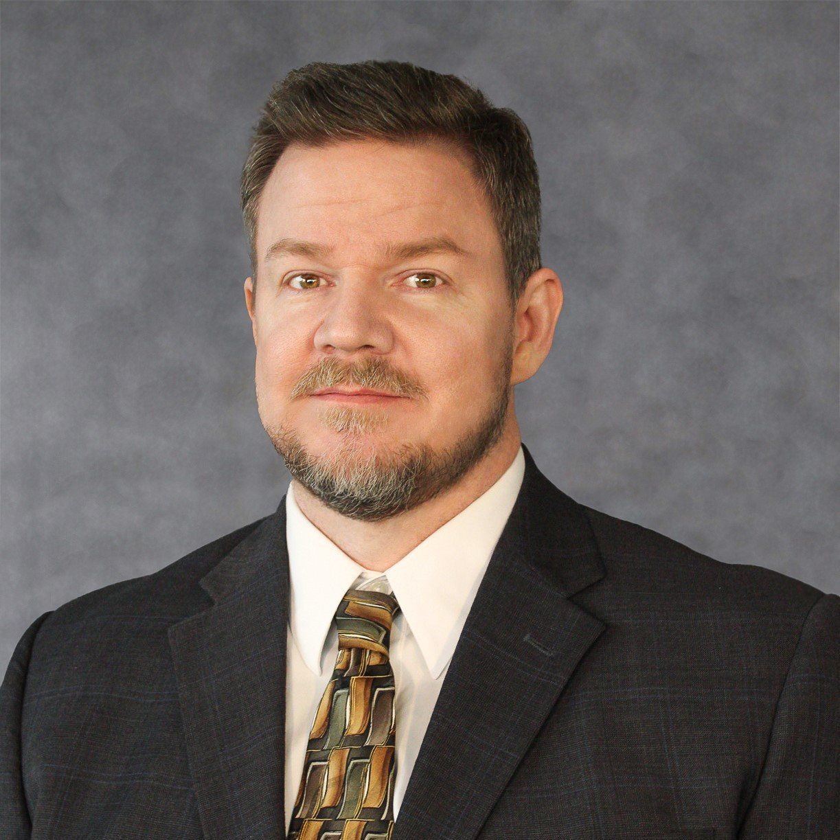 A man with a beard wearing a suit and tie