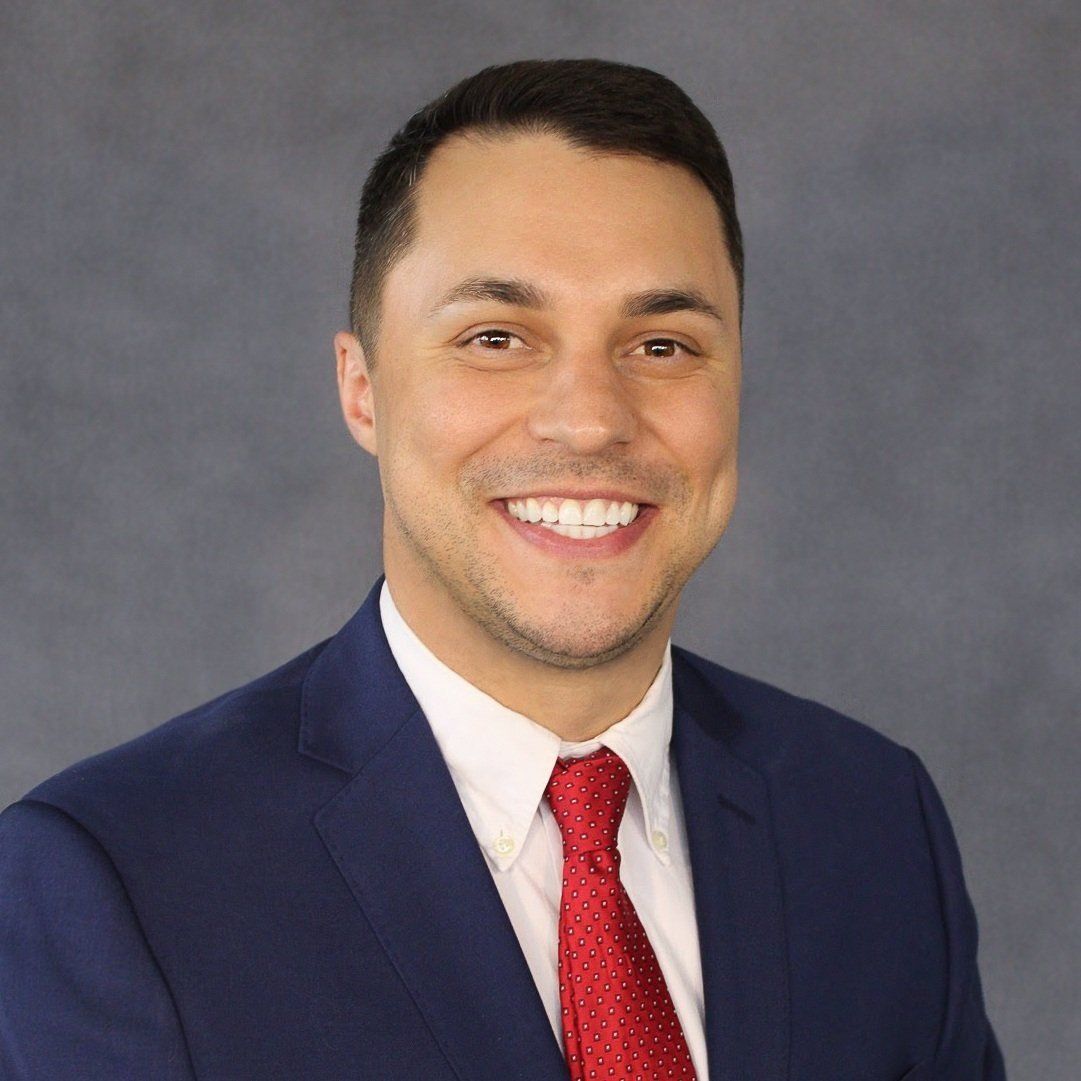 A man in a suit and tie is smiling for the camera.