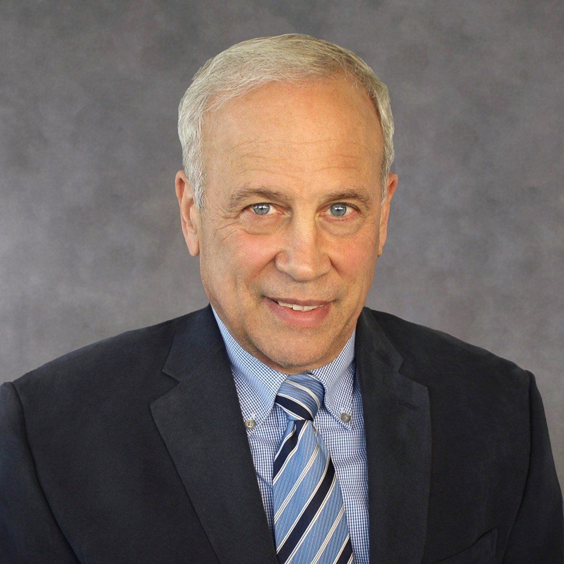 A man in a suit and tie is smiling for the camera.