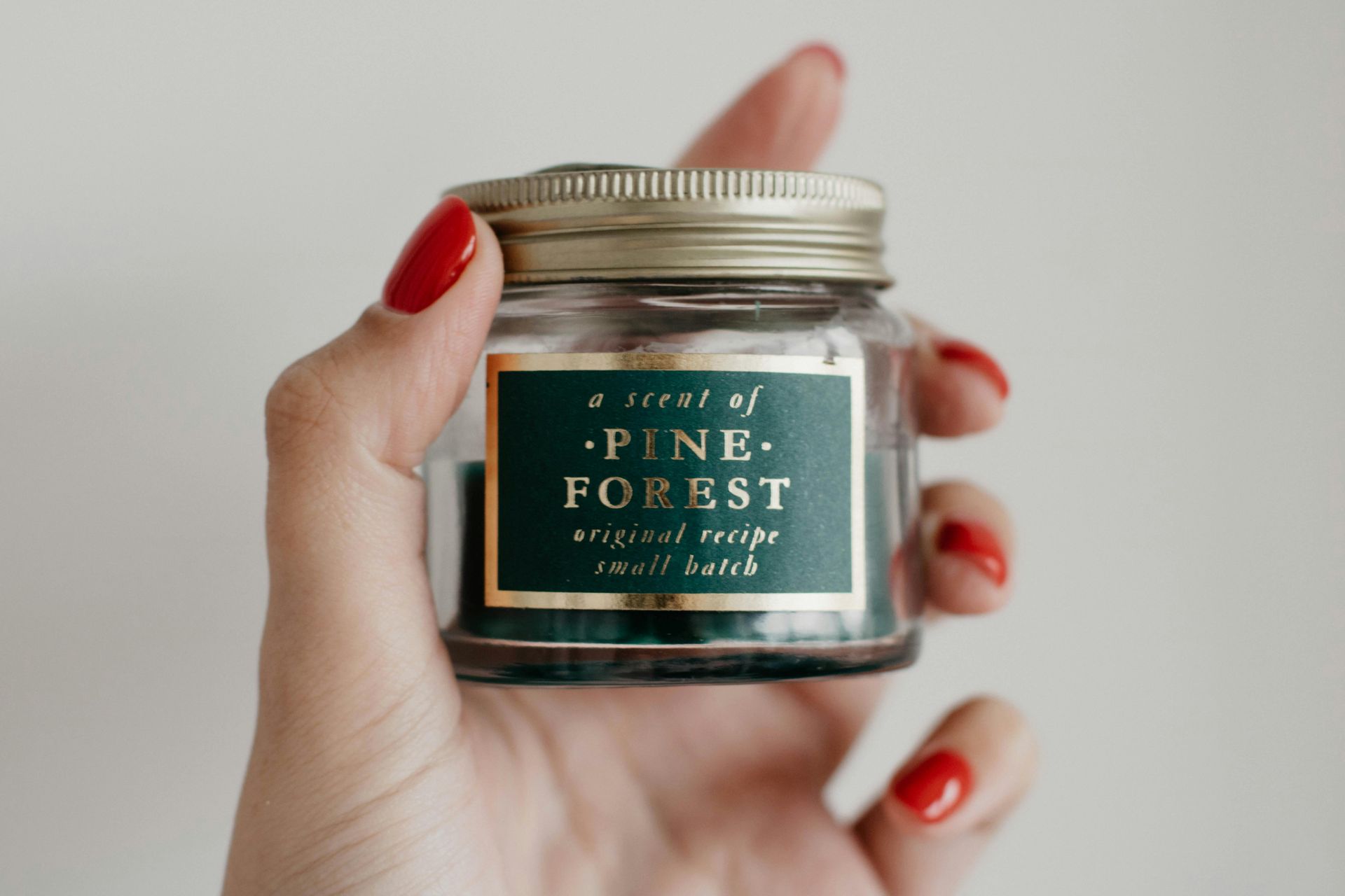 Hand holding a small jar labeled 