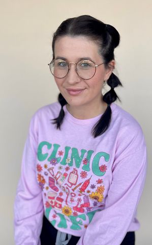 Woman in glasses and pigtails wearing a pink 