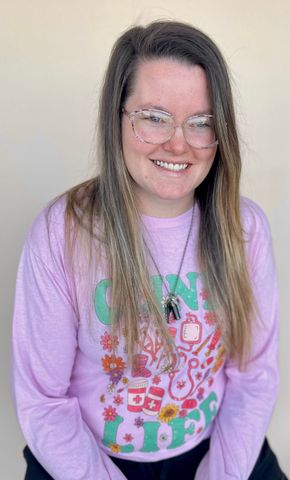 Woman wearing glasses and a pink shirt with 