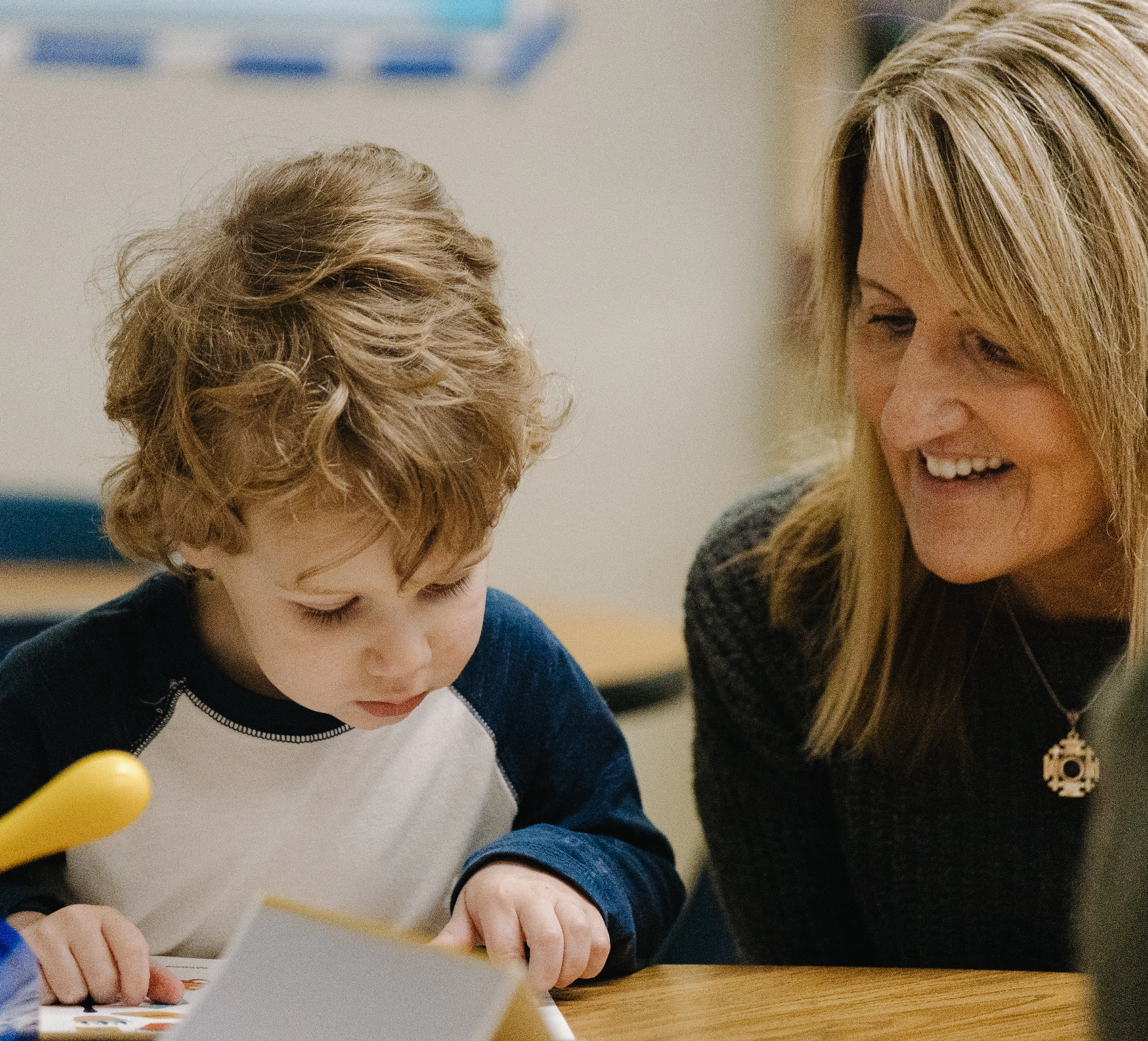 A woman is helping a young boy with his homework