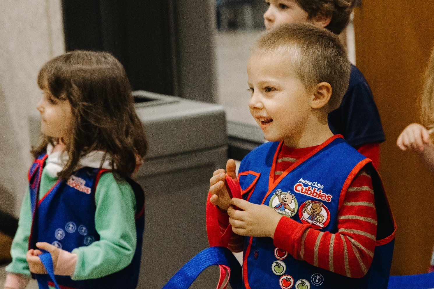 A group of young children wearing girl scout uniforms are standing next to each other.