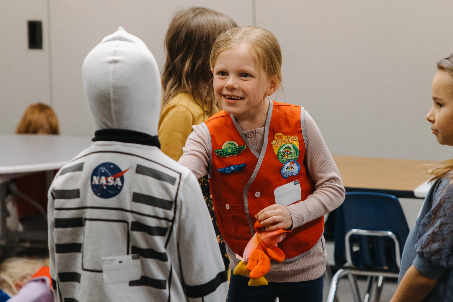 A girl scout in a space suit is talking to a boy in a space suit.
