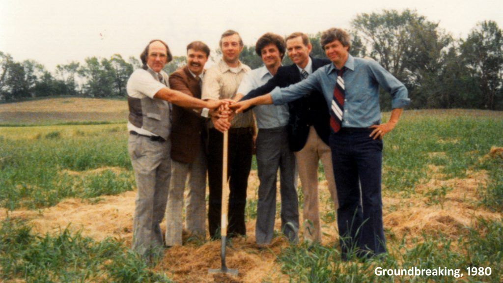 A group of men holding a shovel in a field