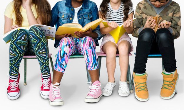A group of children are sitting on a bench reading books.