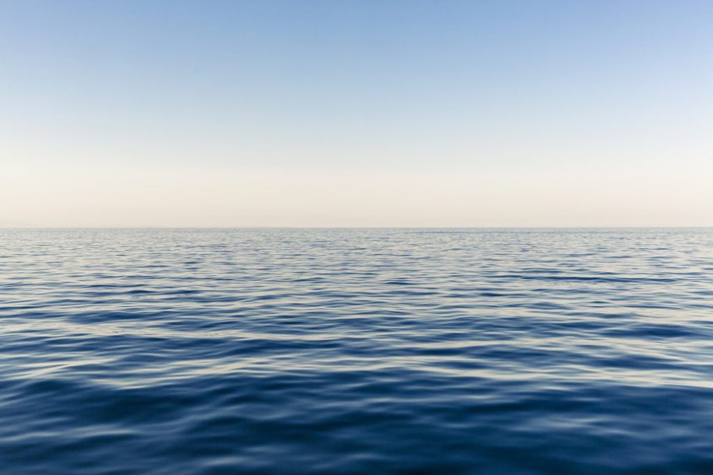 A large body of water with a blue sky in the background.