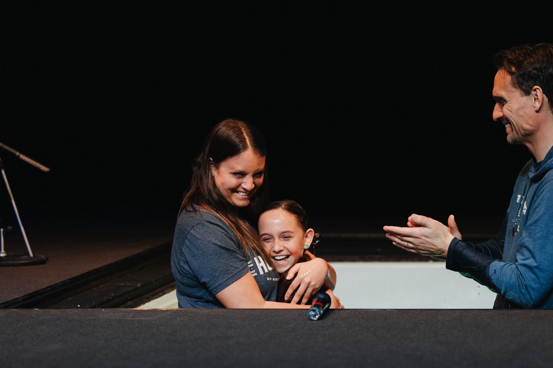 A man is talking to two girls in a bathtub.