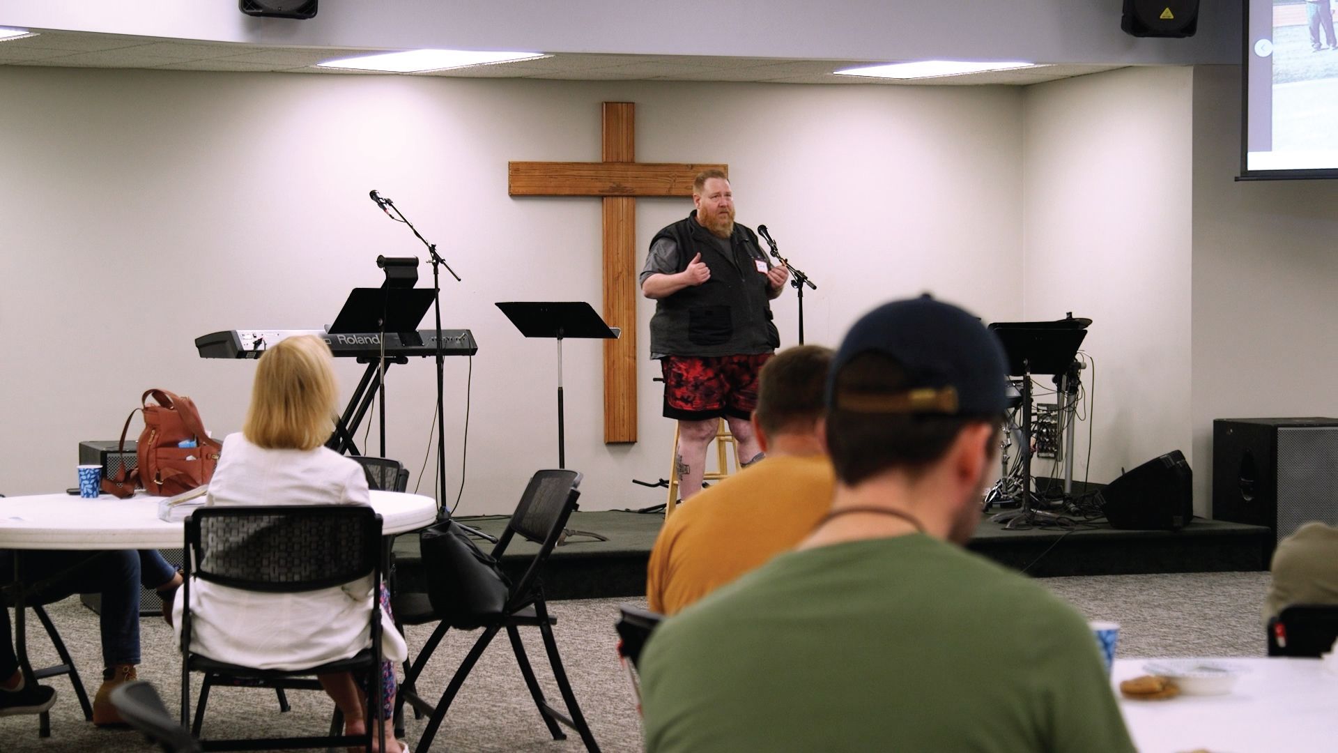 A man is giving a speech in front of a group of people in a church.