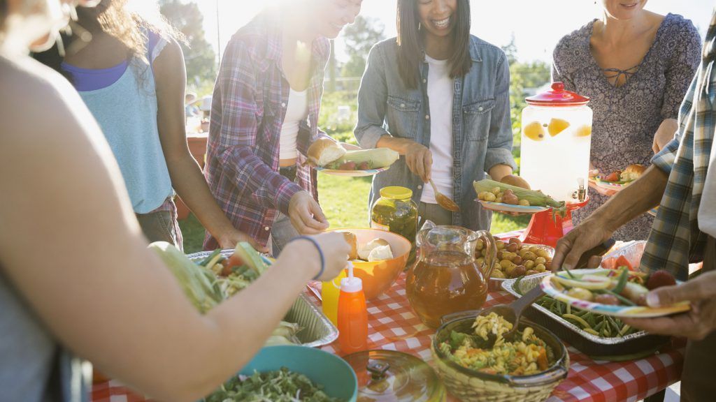 A group of people are gathered around a table eating food.