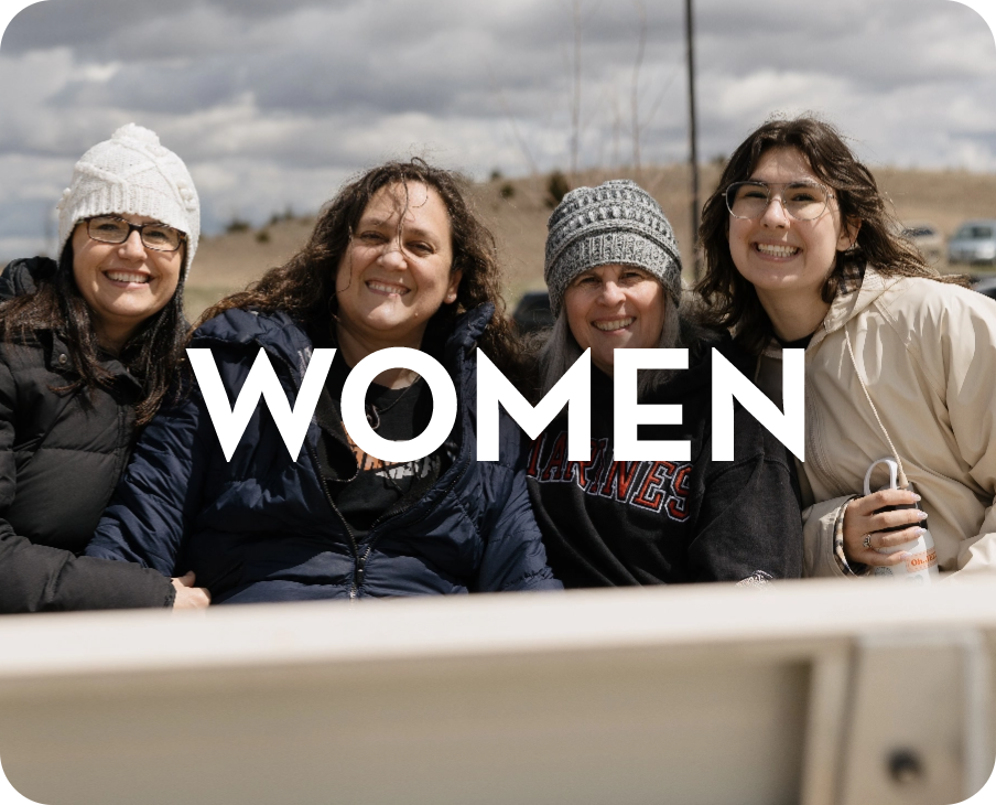 A group of women are sitting in the back of a truck.