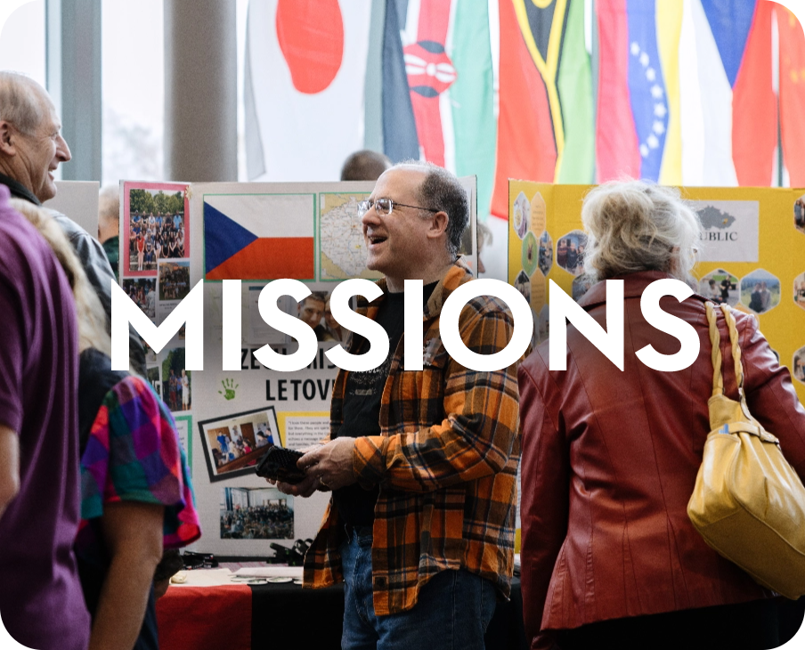 A group of people standing in front of a sign that says missions