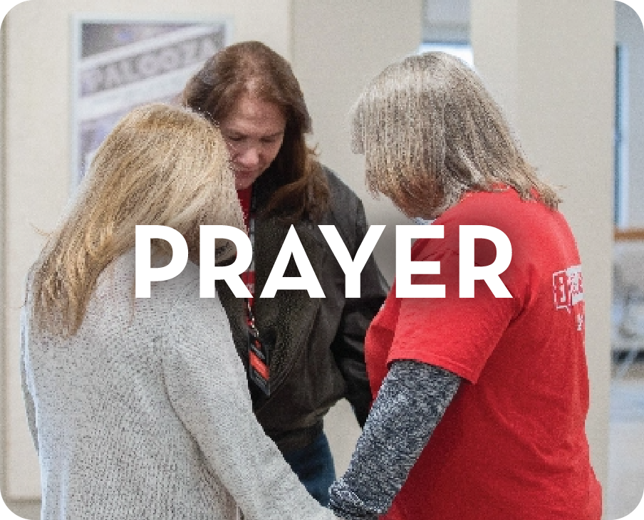 A group of women are praying together in a room.