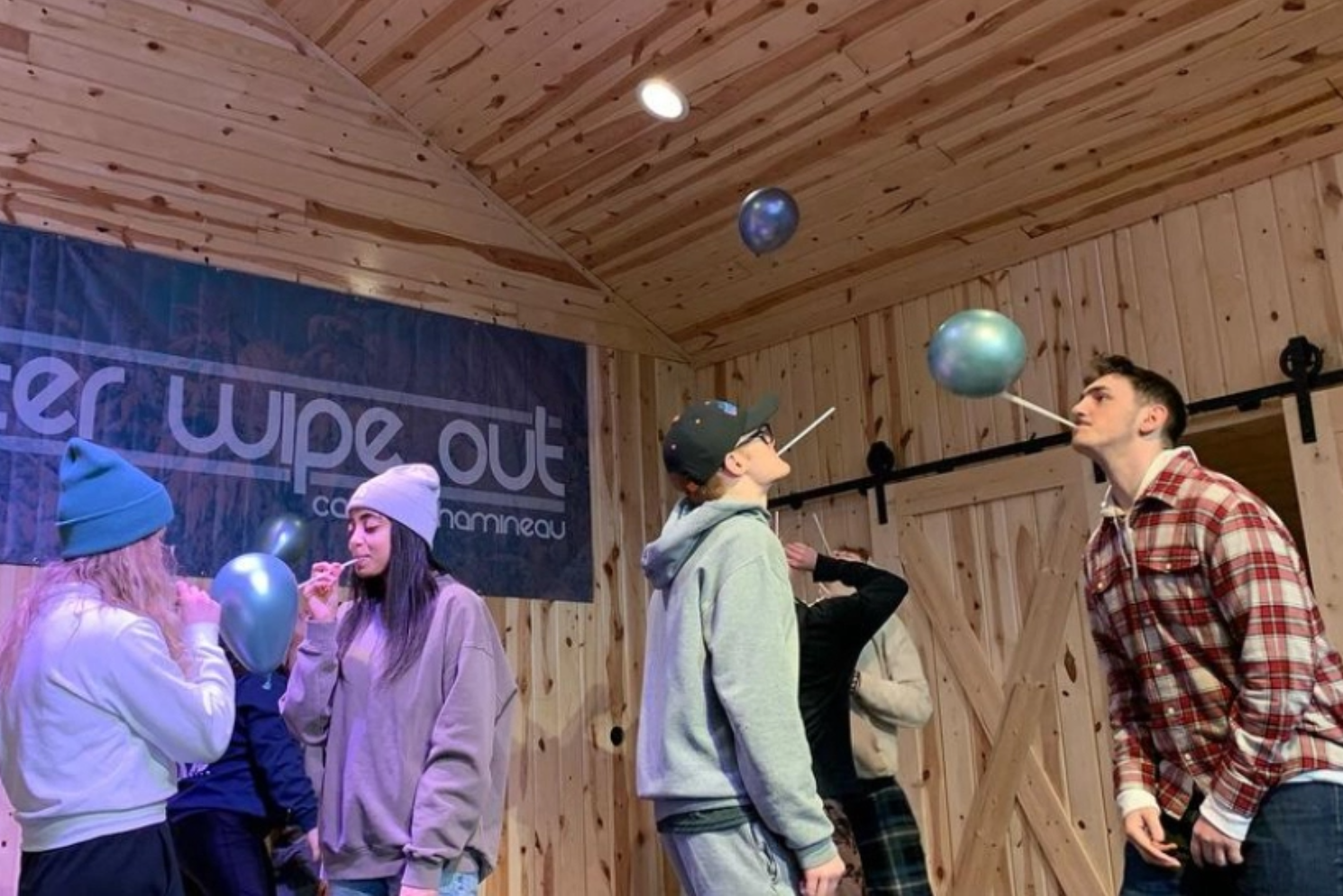 A group of people are blowing up balloons in a room.
