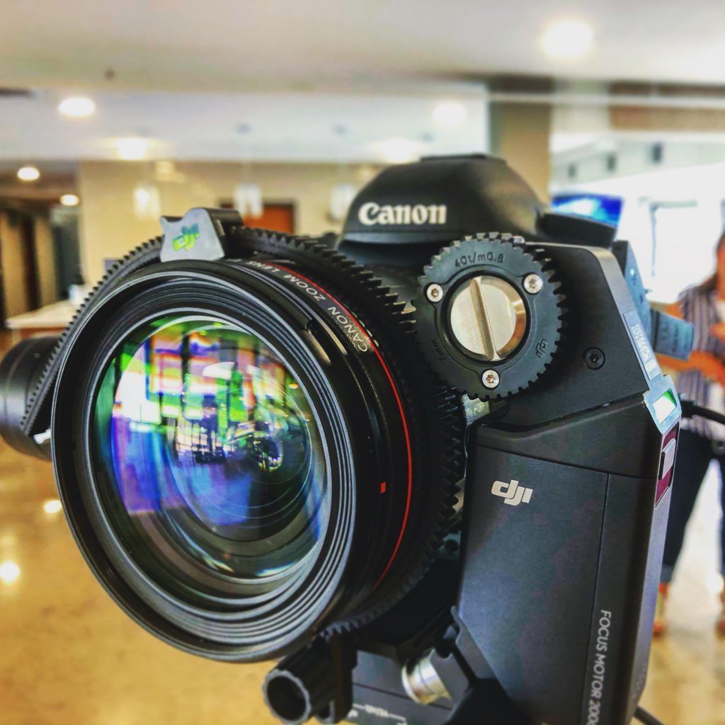 A canon camera is on a tripod in a room