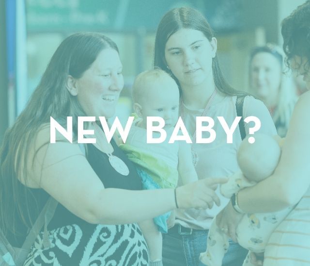A group of women are holding a baby in their arms.