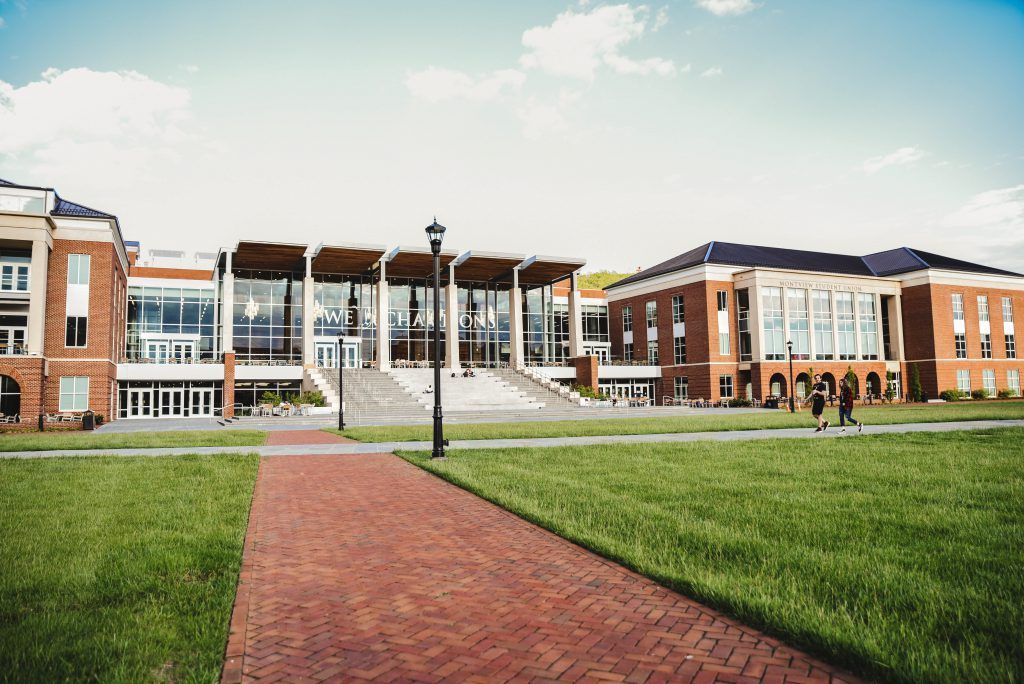 A large brick building with a brick walkway leading to it.