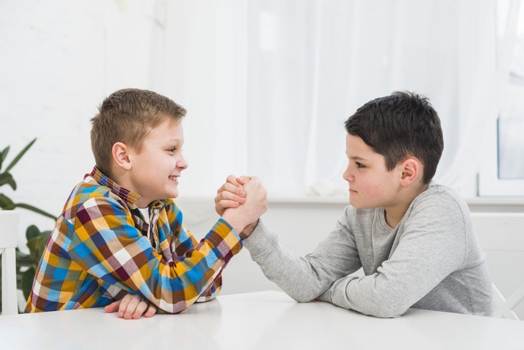 two young boys arm wrestling