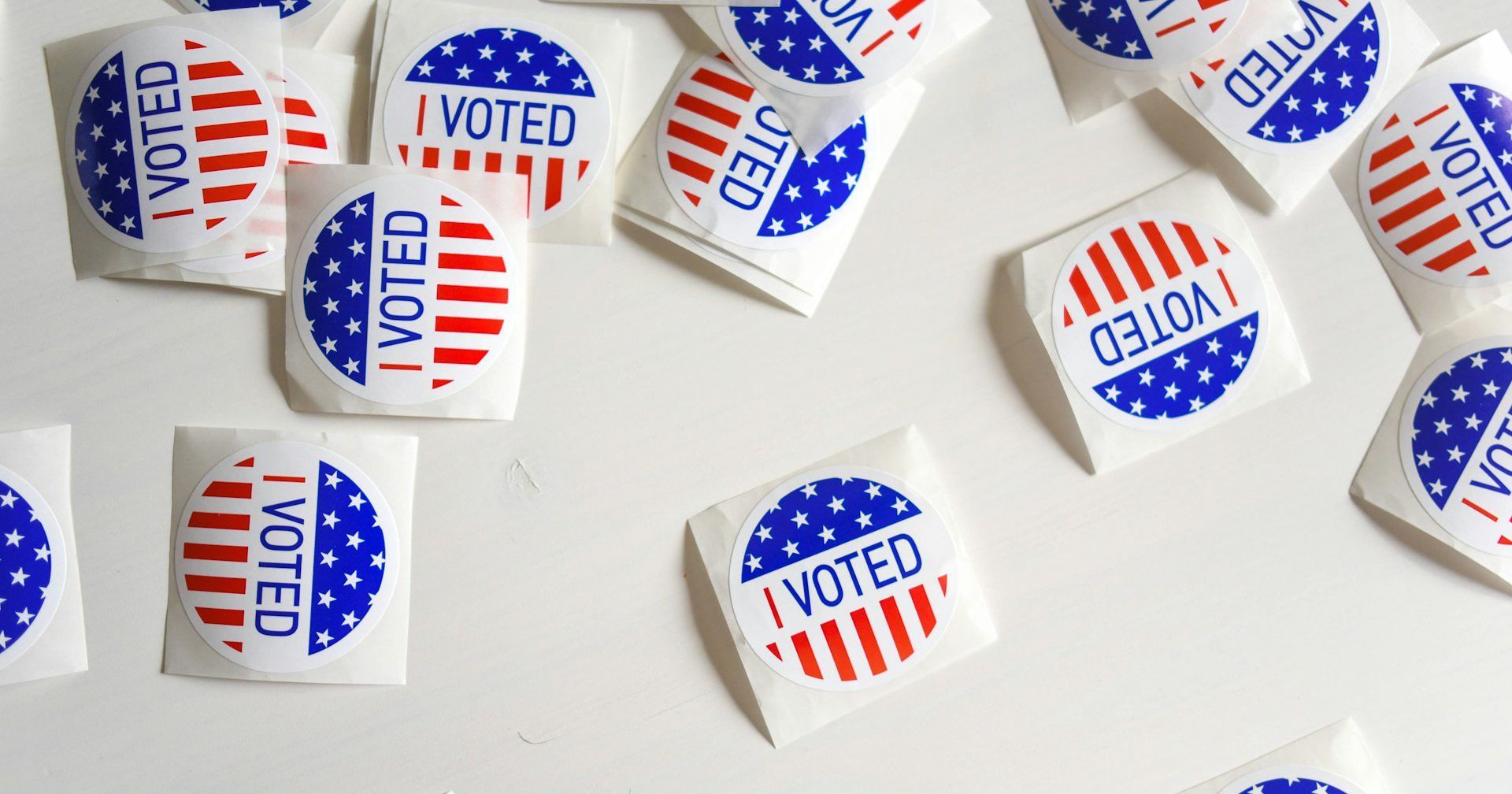 A bunch of i voted stickers on a white surface