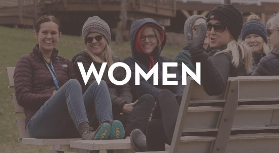 A group of people are sitting on a bench with the word women above them.