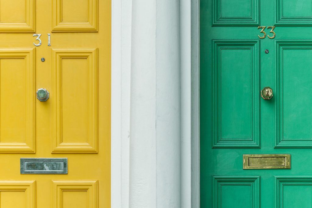 A yellow door and a green door are next to each other.
