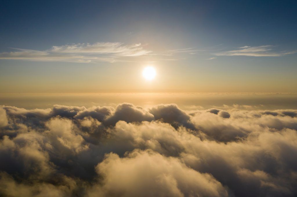 The sun is shining through the clouds in the sky.